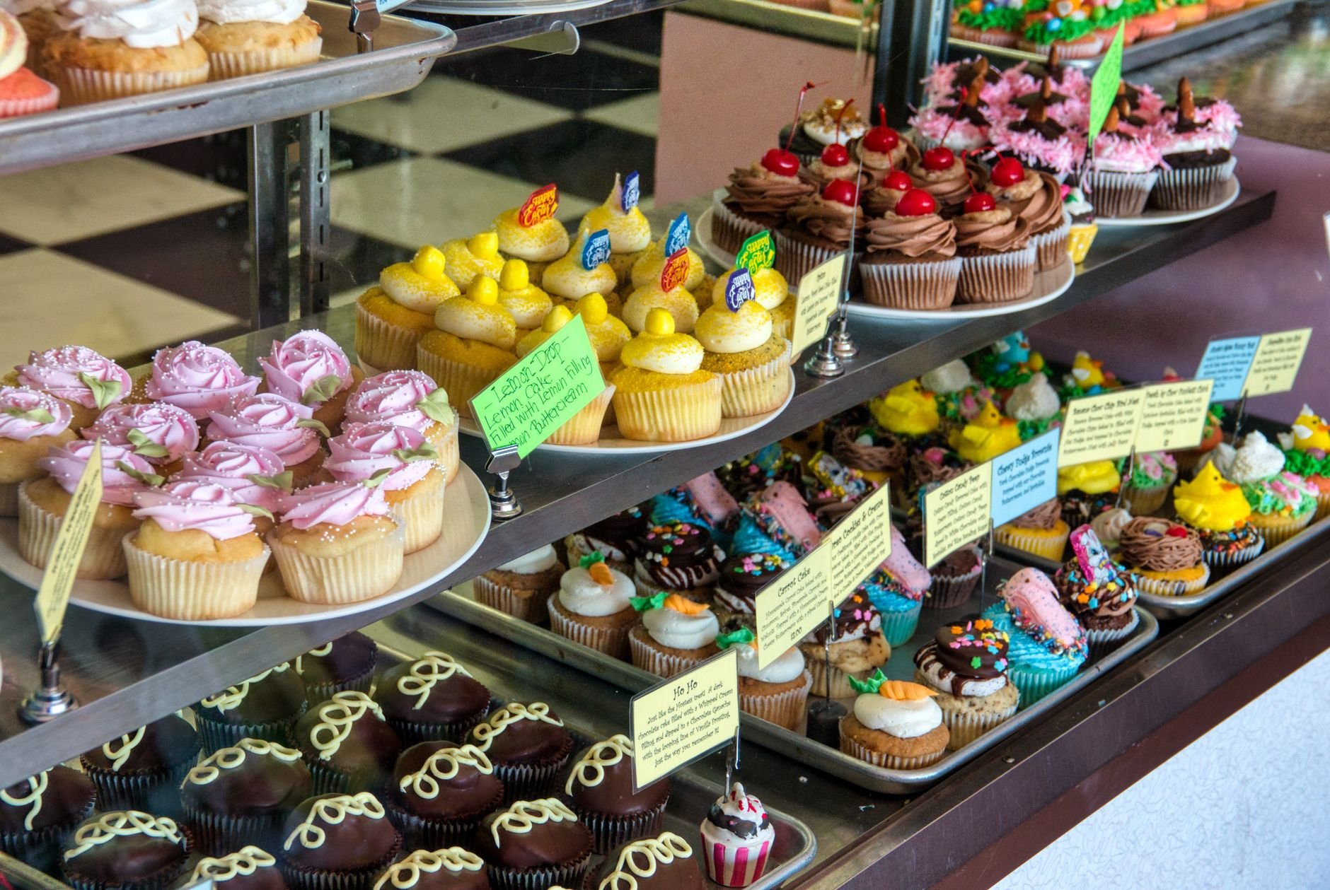Showcase of colorful and decorative cupcakes in a bakery display